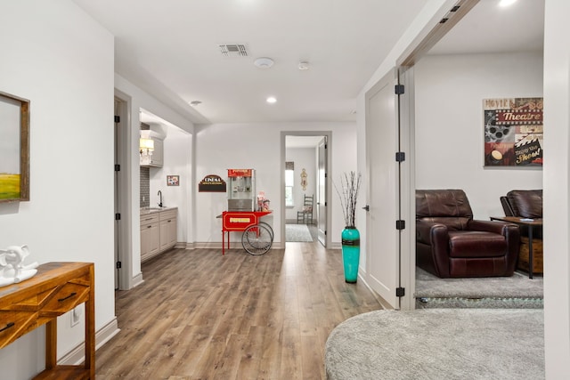 hallway with light hardwood / wood-style floors and sink