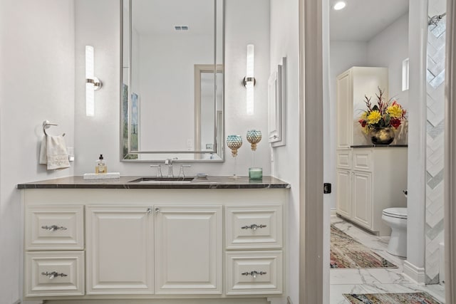 bathroom with toilet, a healthy amount of sunlight, and vanity