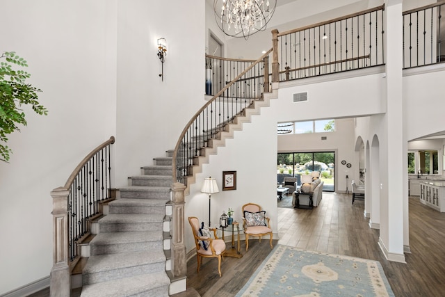 staircase featuring hardwood / wood-style flooring and a towering ceiling