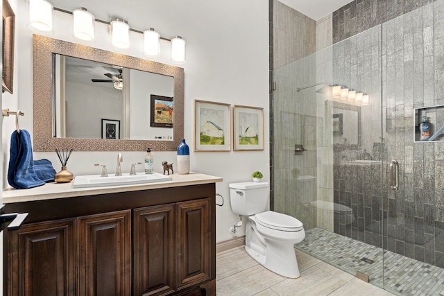 bathroom featuring vanity, toilet, walk in shower, and ceiling fan