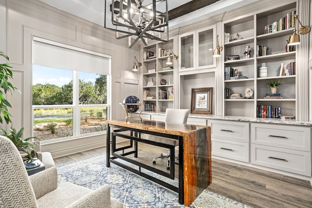 home office with beam ceiling, hardwood / wood-style flooring, and a chandelier