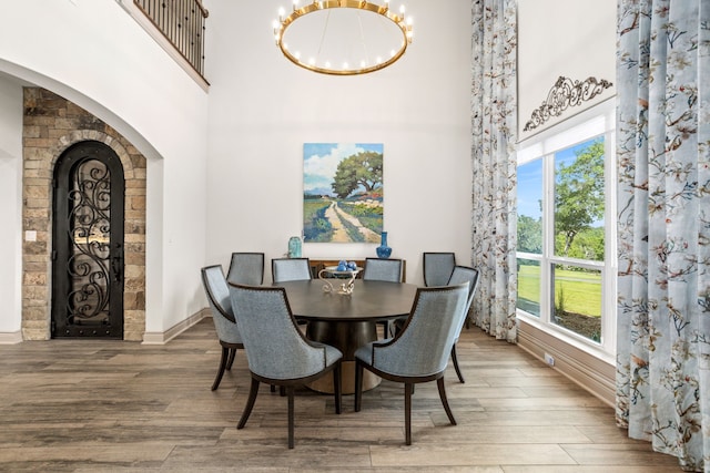 dining space with a healthy amount of sunlight, a chandelier, and hardwood / wood-style floors