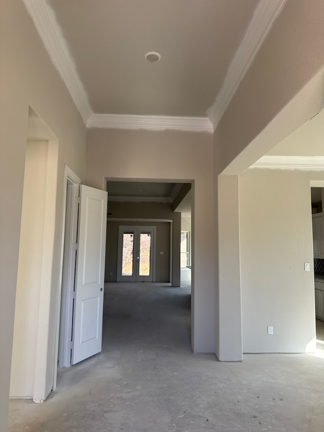 hallway with french doors, concrete flooring, and ornamental molding