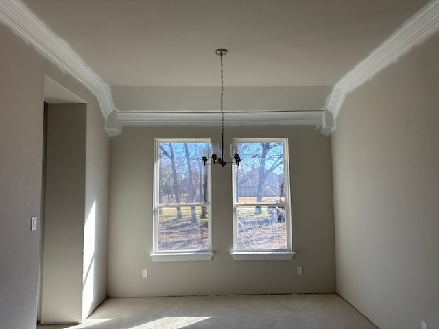 unfurnished dining area with a chandelier and ornamental molding