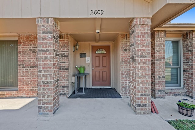 view of exterior entry with brick siding