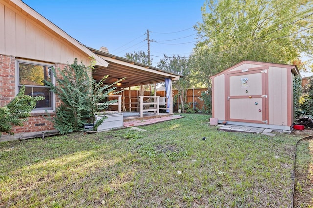 view of yard with a storage shed, an outbuilding, and fence