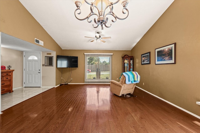 unfurnished room featuring light wood-type flooring, ceiling fan with notable chandelier, and lofted ceiling