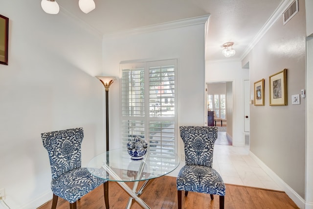 sitting room with ornamental molding and light hardwood / wood-style floors