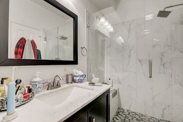 bathroom featuring a shower with door and vanity