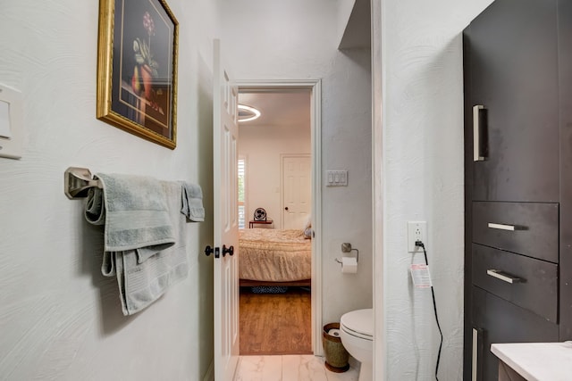 bathroom with toilet, vanity, and hardwood / wood-style flooring