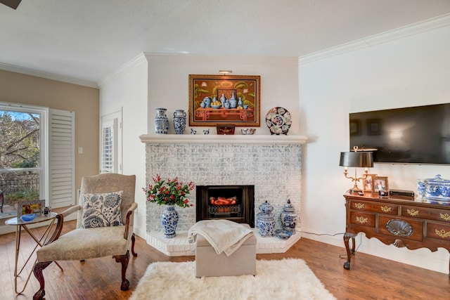 living room with ornamental molding, a fireplace, and hardwood / wood-style flooring