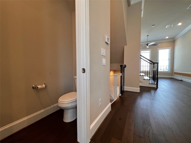 bathroom with toilet, hardwood / wood-style floors, ceiling fan, and ornamental molding