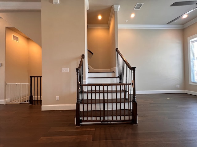 stairs with ornamental molding and hardwood / wood-style floors