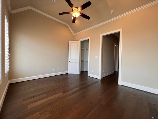 unfurnished bedroom featuring a walk in closet, ceiling fan, lofted ceiling, dark wood-type flooring, and crown molding