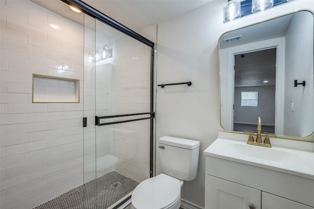 bathroom featuring vanity, toilet, and an enclosed shower