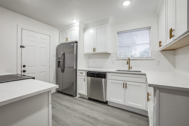 kitchen featuring sink, white cabinetry, stainless steel appliances, light stone counters, and light hardwood / wood-style flooring