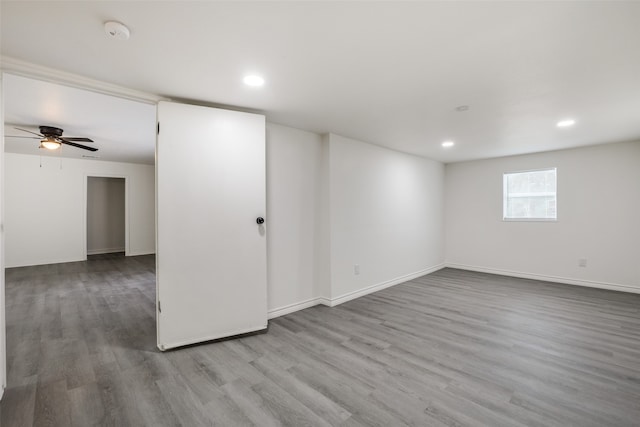 basement with light hardwood / wood-style floors and ceiling fan