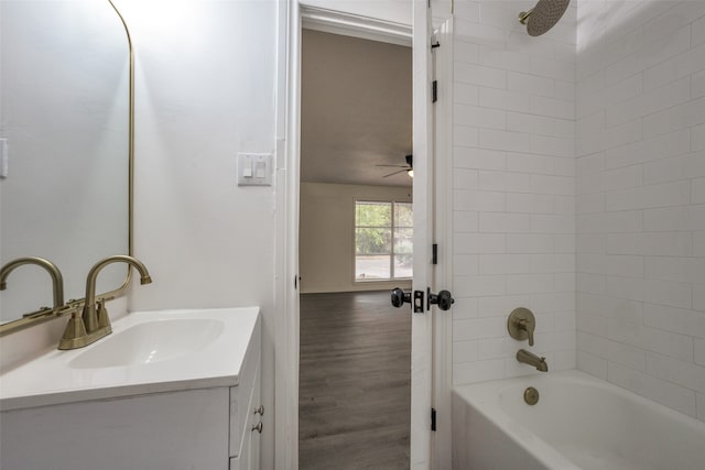 bathroom with vanity, ceiling fan, wood-type flooring, and tiled shower / bath