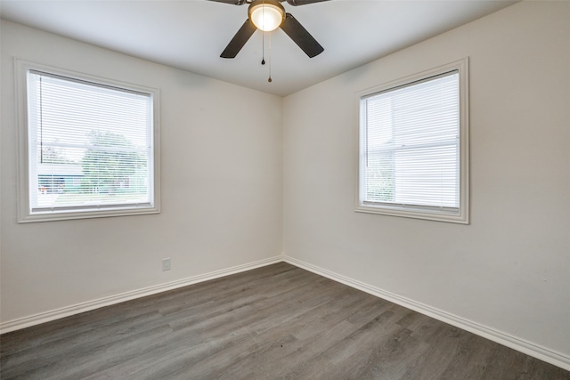 unfurnished room featuring a wealth of natural light, dark hardwood / wood-style floors, and ceiling fan