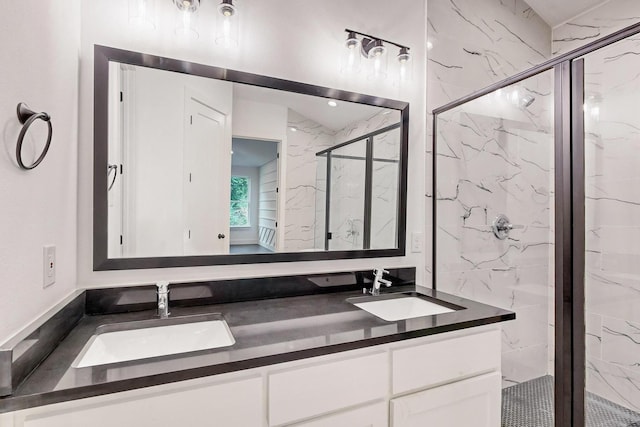 full bath with double vanity, a marble finish shower, and a sink