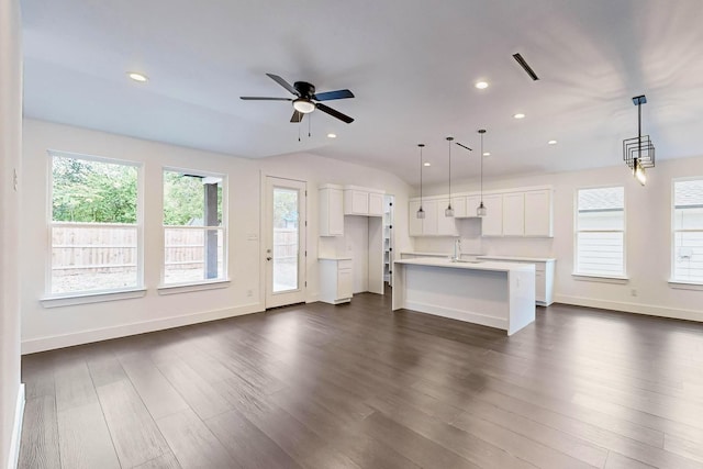 unfurnished living room with dark hardwood / wood-style flooring, lofted ceiling, sink, and ceiling fan