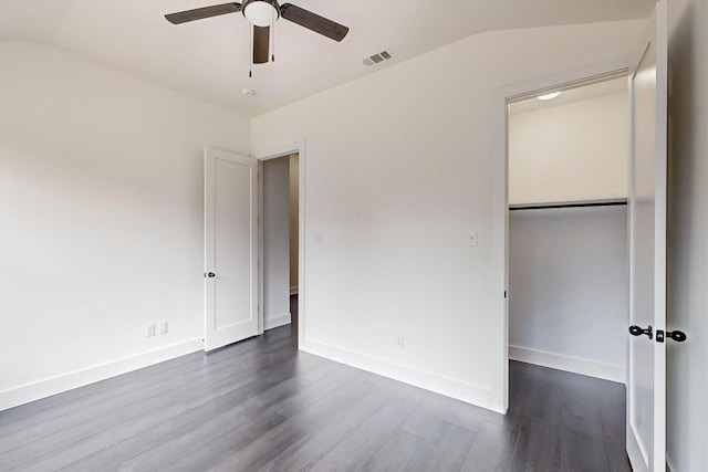 unfurnished bedroom with dark wood-style floors, lofted ceiling, visible vents, ceiling fan, and baseboards