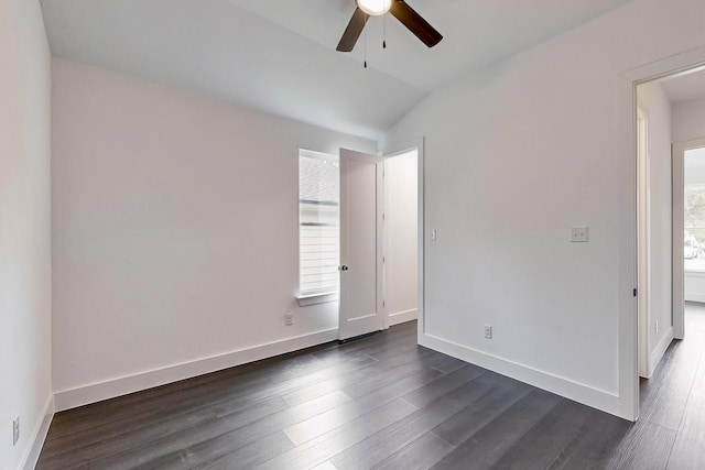 spare room featuring dark wood-type flooring, a ceiling fan, and baseboards