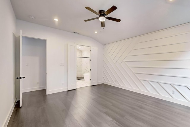 unfurnished bedroom with ceiling fan, ensuite bathroom, dark hardwood / wood-style flooring, and vaulted ceiling