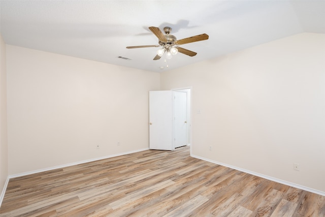 spare room featuring lofted ceiling, light wood-type flooring, and ceiling fan