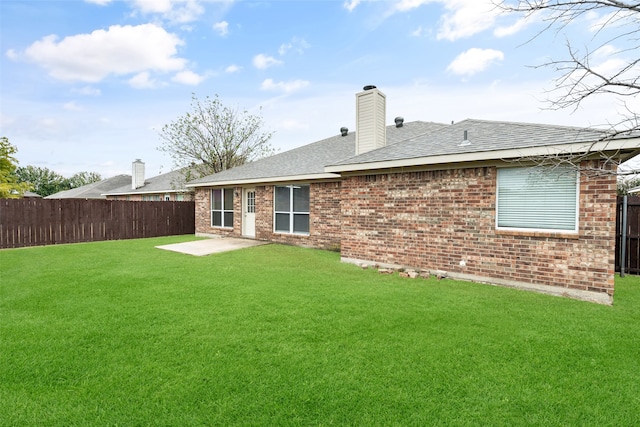 rear view of property featuring a patio area and a lawn