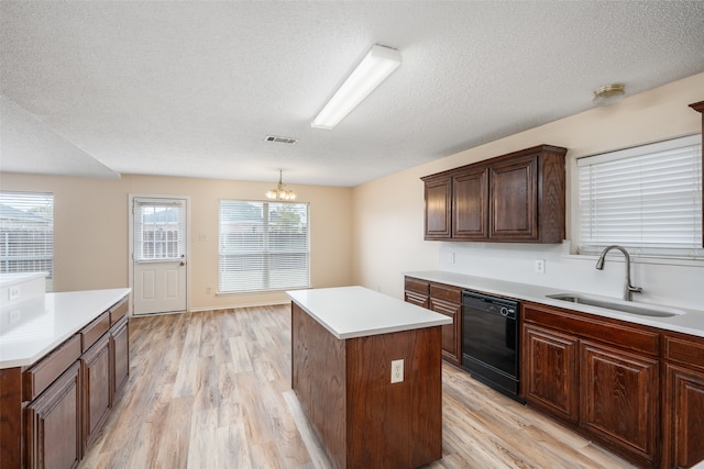 kitchen featuring black dishwasher, hanging light fixtures, light wood-type flooring, sink, and a center island