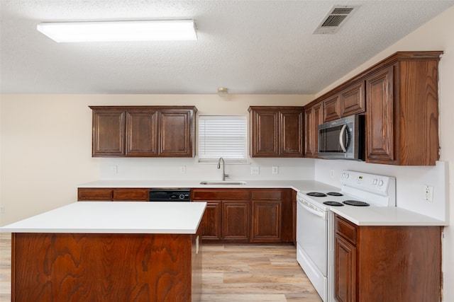 kitchen with light hardwood / wood-style flooring, white electric range, sink, and a center island