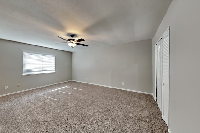 empty room with carpet floors, a textured ceiling, and ceiling fan