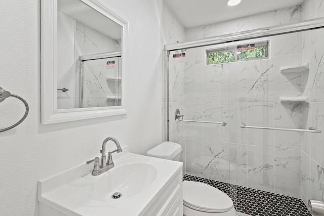 bathroom with vanity, toilet, and a shower with door