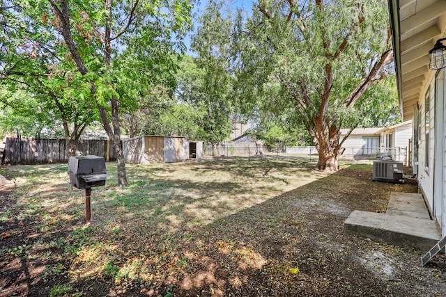 view of yard featuring a shed and central AC unit