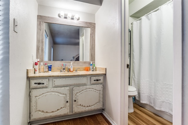 bathroom featuring toilet, hardwood / wood-style floors, a shower with curtain, and vanity