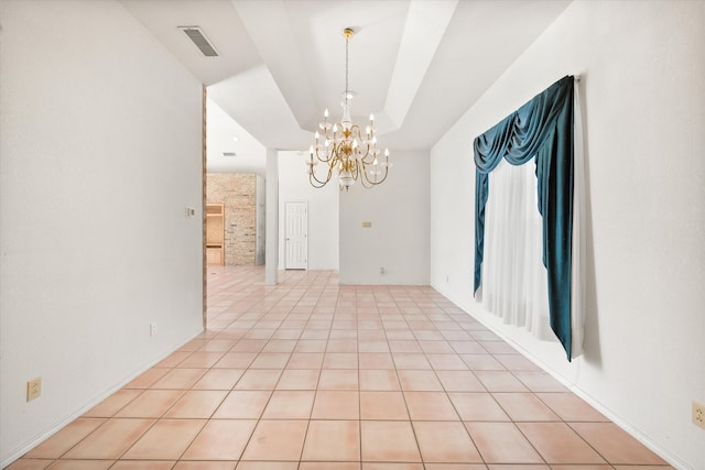 empty room with a chandelier and light tile patterned flooring