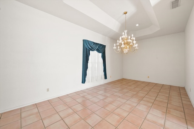 tiled spare room with a raised ceiling and an inviting chandelier