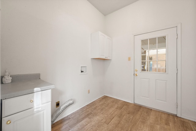 laundry area featuring electric dryer hookup, hookup for a washing machine, cabinets, and light wood-type flooring