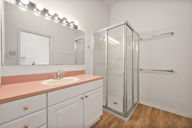 bathroom featuring hardwood / wood-style floors, vanity, and an enclosed shower