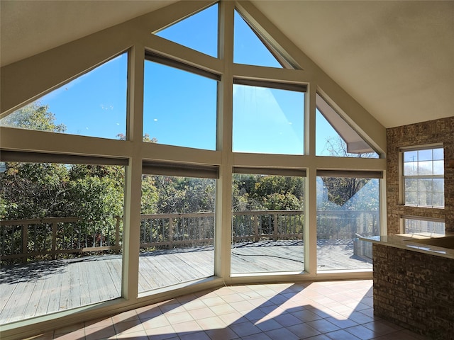 unfurnished sunroom featuring vaulted ceiling and plenty of natural light