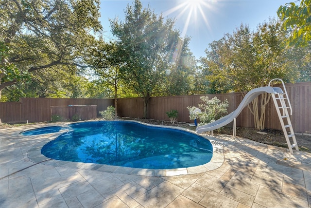 view of pool featuring a water slide and a patio