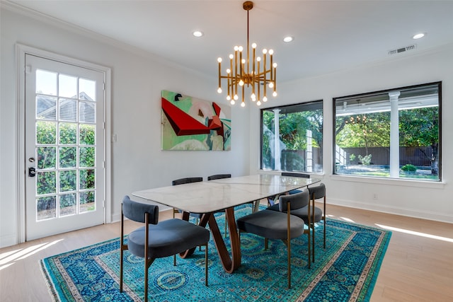 dining room with a chandelier, ornamental molding, and light hardwood / wood-style flooring