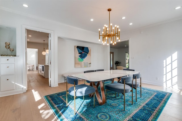 dining area with crown molding, light hardwood / wood-style flooring, and a notable chandelier