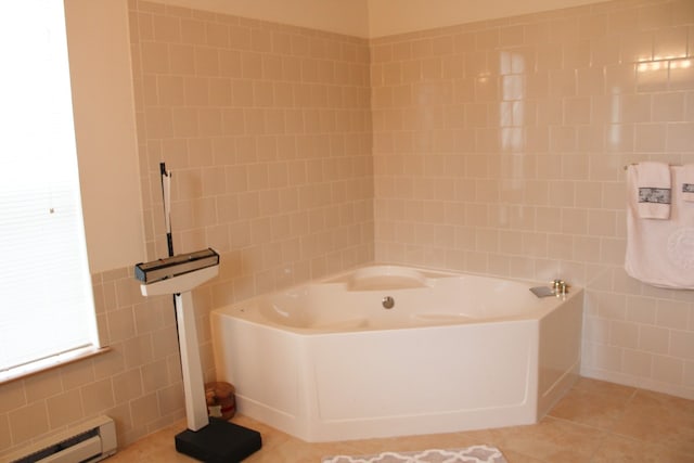 bathroom featuring tile patterned floors, tile walls, baseboard heating, and a bathing tub