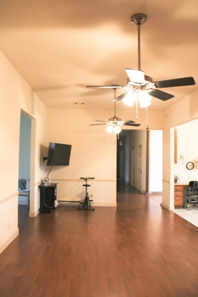 unfurnished living room featuring ceiling fan and dark hardwood / wood-style floors