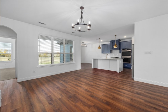 unfurnished living room with dark wood-type flooring and a chandelier