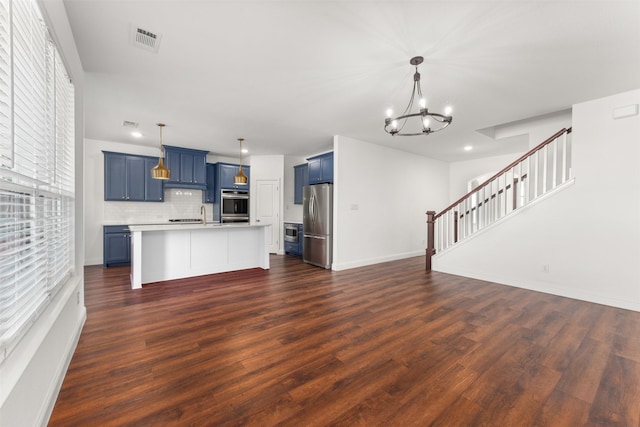 unfurnished living room with a wealth of natural light, dark hardwood / wood-style floors, and an inviting chandelier