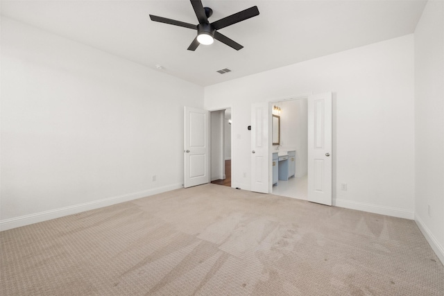 unfurnished bedroom with light carpet, ceiling fan, and ensuite bath