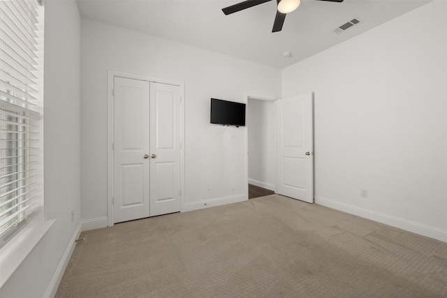 unfurnished bedroom with a closet, ceiling fan, and carpet flooring